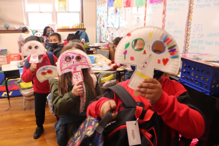 Kindergarten students create sugar skull masks for day of the dead. 